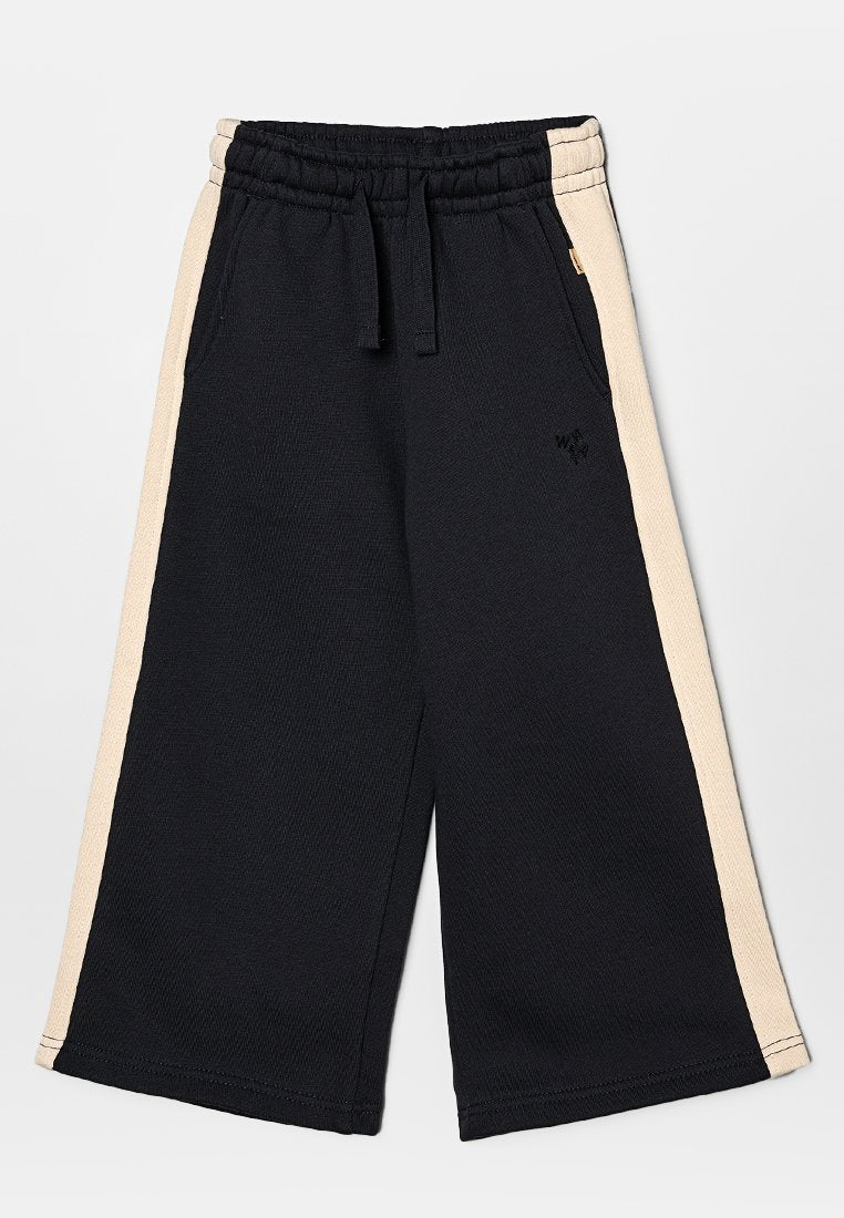 Schwarze weit geschnittene Sweatpants mit beigen Seitestreifen, ausgestattet mit einem elastischen Taillenbund und weichem Material. Dezentes Logo auf der Vorderseite.