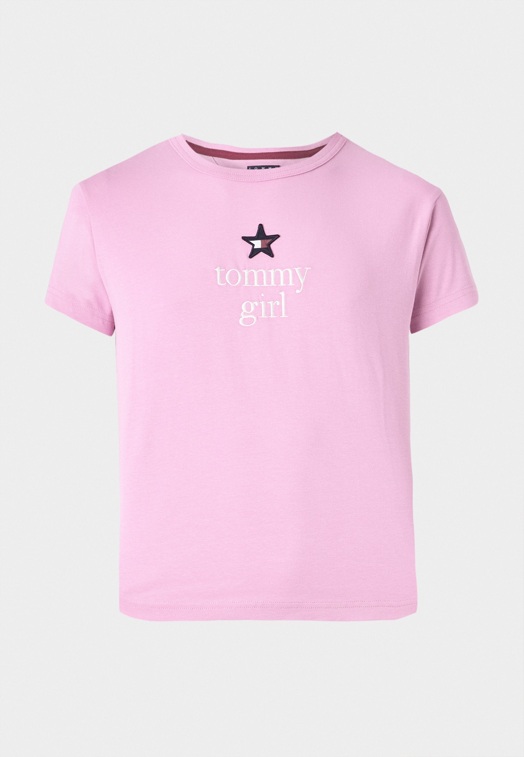 Rosa T-Shirt mit kurzen Ärmeln aus weichem Stoff, mit weißem "tommy"-Text und einem schwarzen Stern über dem Wort "girl". Einfaches Design.