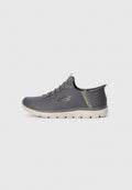 Grauer Sportschuh mit Obermaterial aus Mesh, strukturiertem hinteren Bereich und weißer Sohle. Verfügt über ein flexibles Design und minimalistische Schnürsenkel, geeignet für aktive Nutzung.