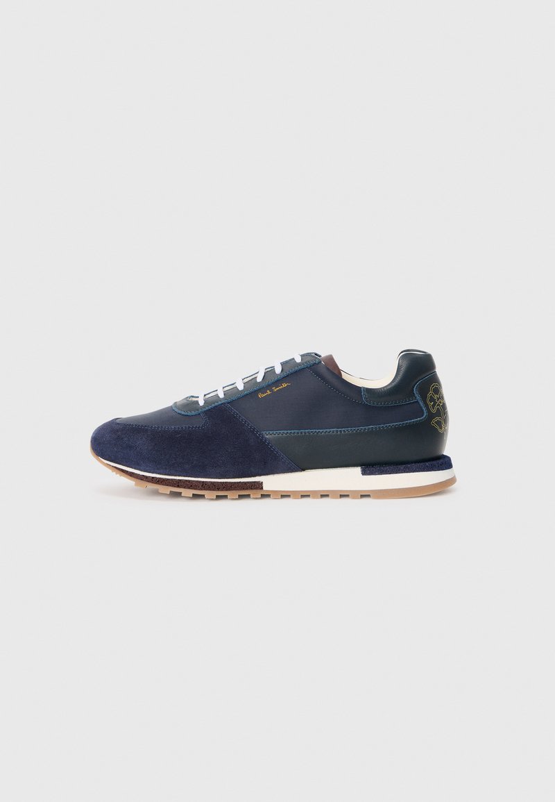 Navyblaue Wildleder- und Ledersneaker mit weißen Schnürsenkeln, einer strukturierten Sohle und einem braunen Akzent am Hinterteil mit einem Logodetail.