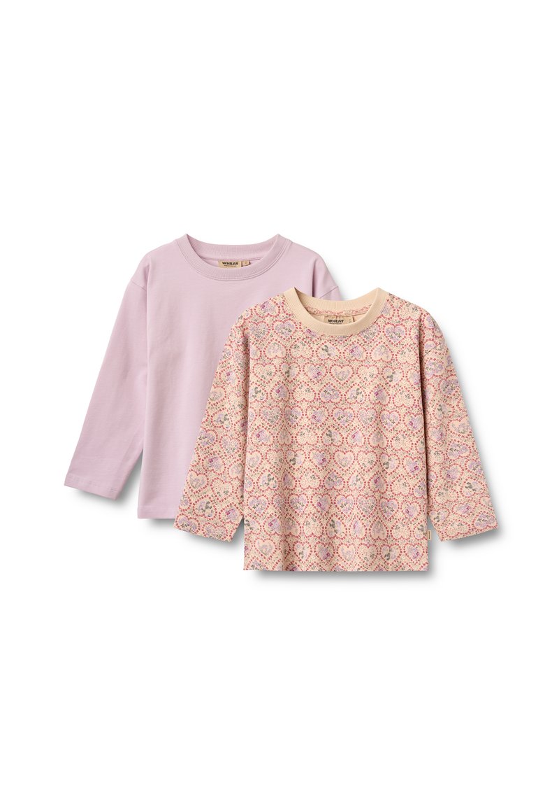 Zwei langärmelige Kinderhemden, eines einfarbig helllila, das andere beige mit einem rosa Herzmuster, beide mit rundem Ausschnitt.