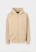 Beige Kapuzenpullover mit Reißverschluss, Fronttaschen und gerippten Bündchen. Hergestellt aus weichem Stoff, mit einem dezenten Logo auf der Brust.