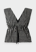 Schwarzes und weißes Polka-Dots-Oberteil mit tiefem V-Ausschnitt, ärmellosem Design, gerafftem Bund mit verstellbarem Bindegürtel und glatter Stoffstruktur.