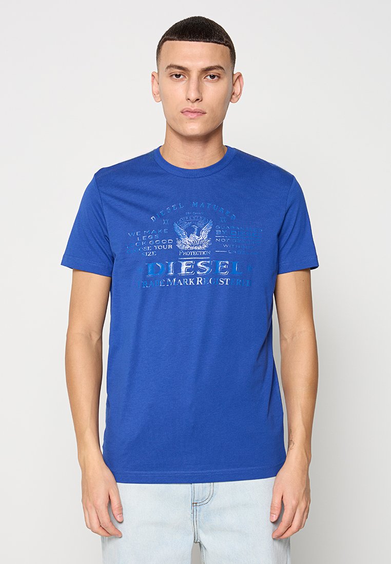 Königsblaue Baumwoll-T-Shirt mit kurzen Ärmeln und Rundhalsausschnitt, ausgestattet mit erhabenem, grafischen Text und einem Logo in einem leicht dunkleren Farbton.