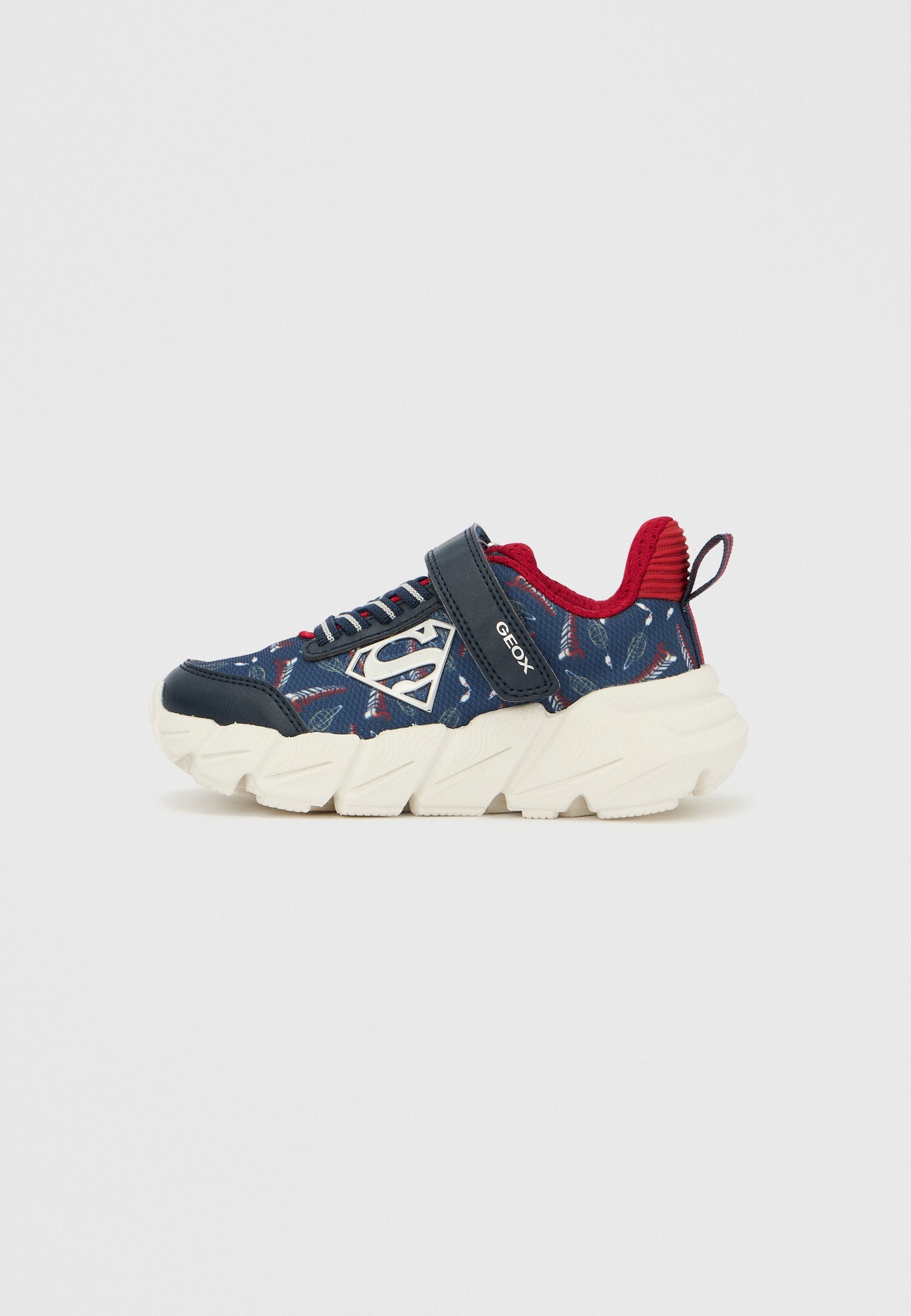 Marineblaue und rote Sneaker mit gemustertem Obermaterial aus Stoff, weißer klobiger Sohle und verstellbarem Riemen. Mit Logo und strukturierten Akzenten.