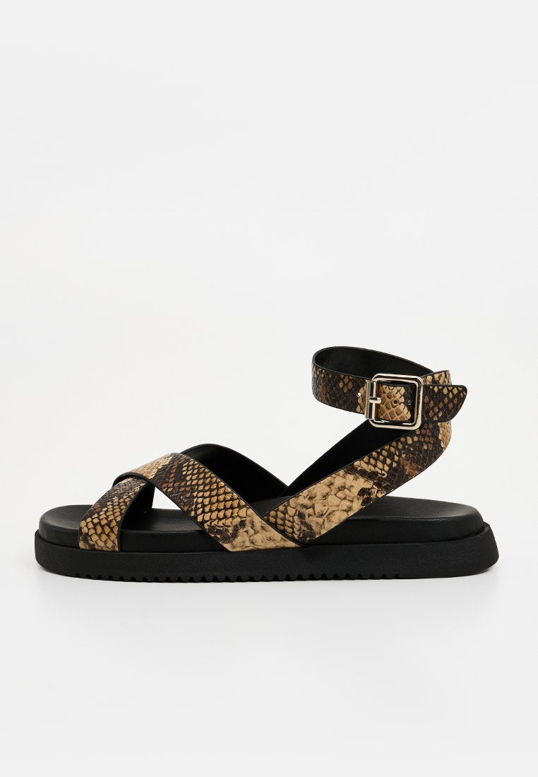 Python-musterte Sandalen mit überkreuzten Riemen in Brauntönen und Schwarz. Verfügt über eine schwarze Gummisohle und einen verstellbaren Knöchelriemen.