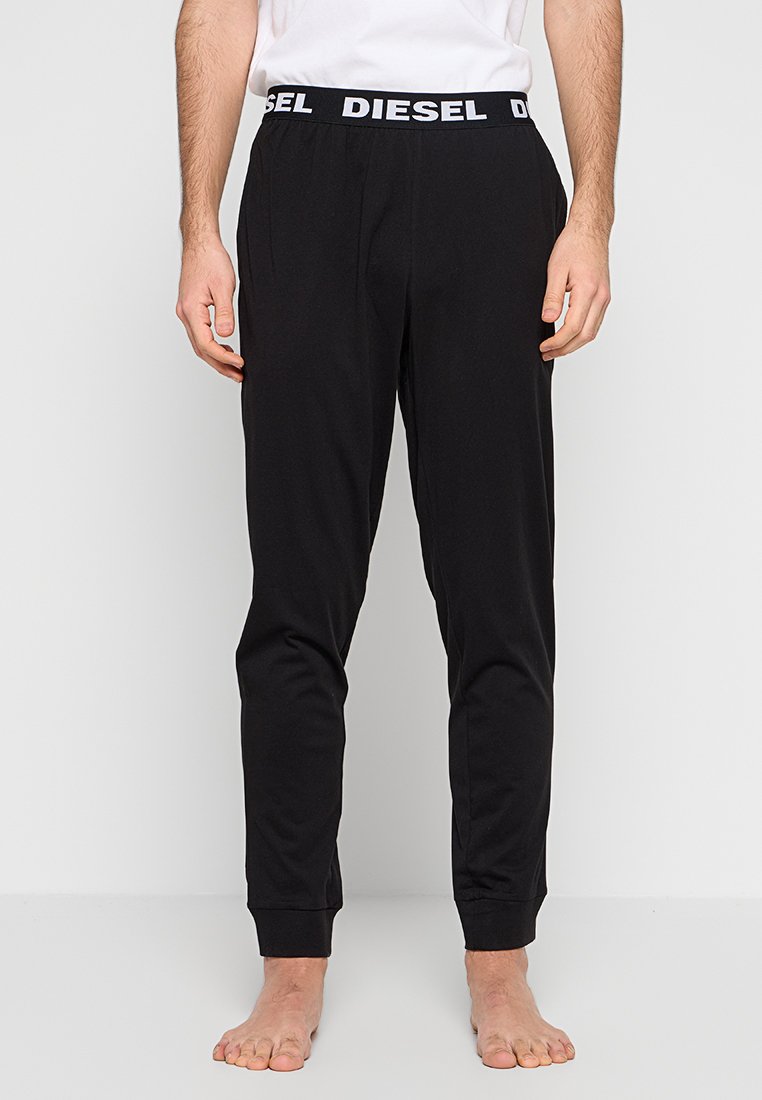 Schwarze Sweatpants mit figurbetontem Schnitt, elastischem Bund mit weißem "DIESEL"-Logo und Bündchen an den Knöcheln. Hergestellt aus einem weichen, glatten Material.
