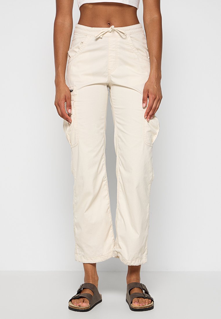 Beige Cargo-Hosen mit lockerer Passform, Kordelzugbund, seitlichen Taschen und schmalen Fußabschlüssen. Hergestellt aus weichem, atmungsaktivem Stoff.