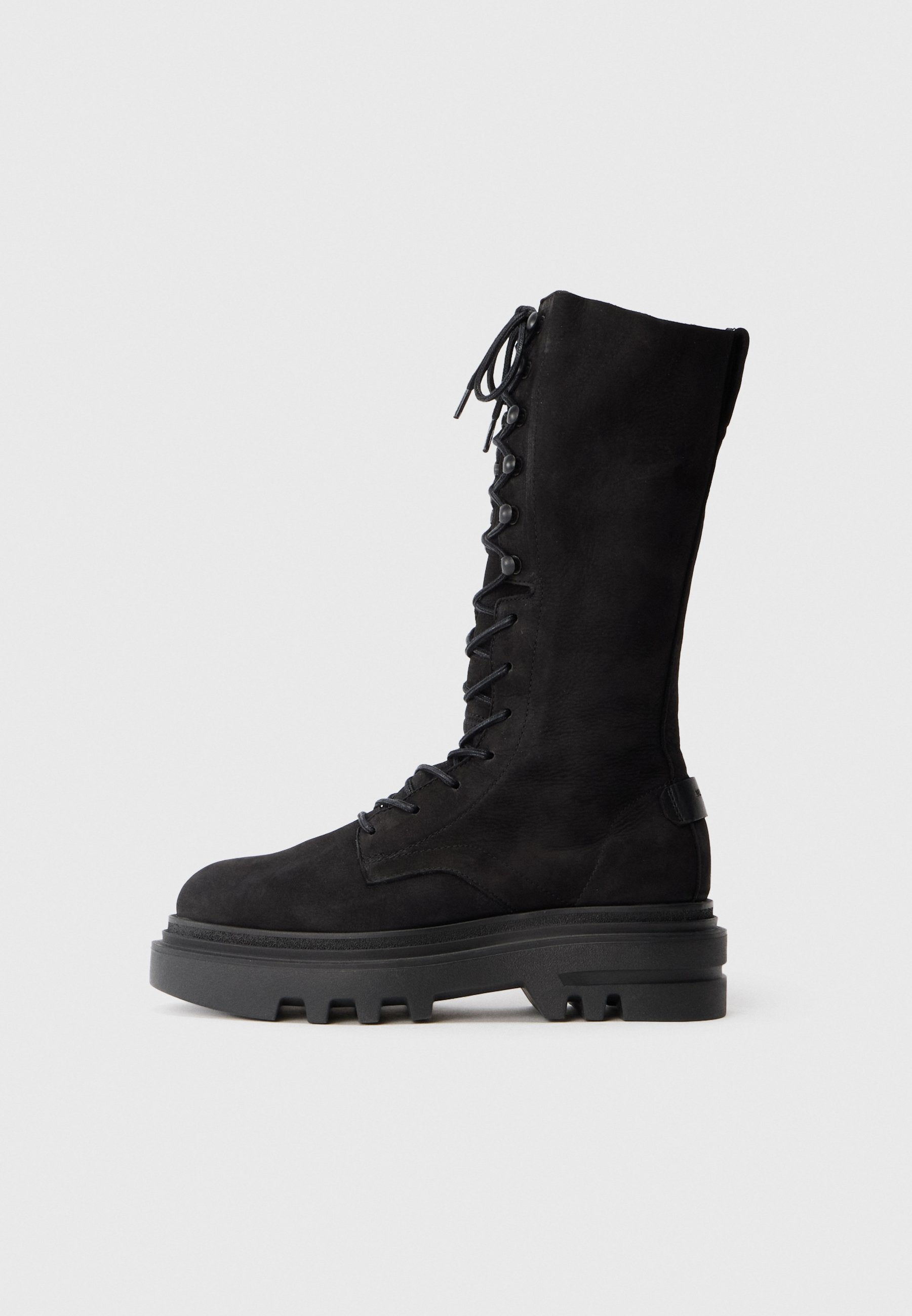 Schwarze knielange Schnürstiefel aus Wildleder, mit einer dicken Gummisohle mit einem robusten Profil und Metallösen für die Schnürsenkel.