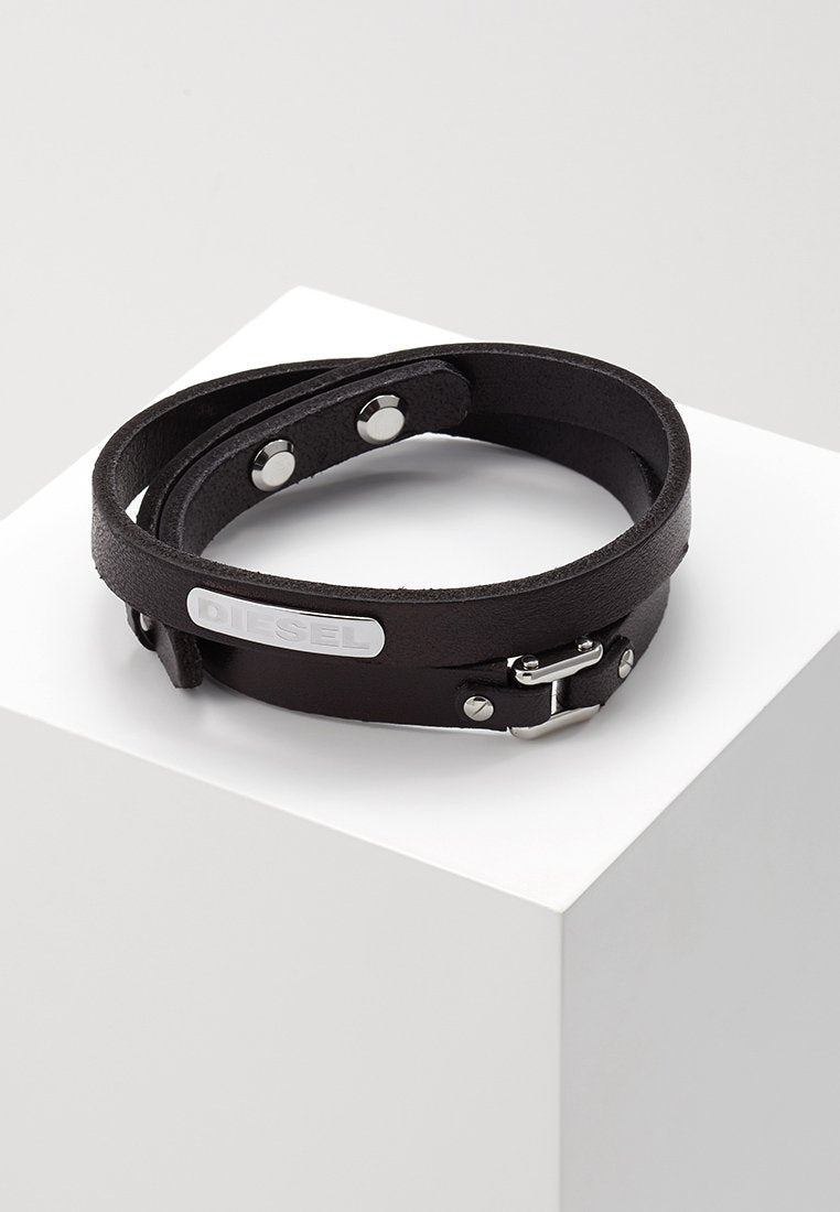 Schwarzes Lederarmband mit zwei Riemen, silbernem Beschlag und einem Logo-Plättchen. Verfügt über Druckknöpfe und eine Schnalle zur Anpassung.
