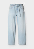 Hellblaue, weite Denim-Jeans mit Kordelzugbund, vorderen Taschen und Gürtelschlaufen vor einfarbigem Hintergrund.