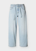Hellblaue, weite Denim-Jeans mit Kordelzugbund, vorderen Taschen und Gürtelschlaufen vor einfarbigem Hintergrund.