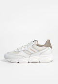 Weißer Sneaker mit einem Design aus verschiedenen Materialien, das Mesh und Leder kombiniert. Eine auffällige beige Ferse und ein goldener Branding-Detail auf der Seite.