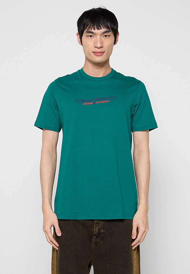 Türkises Baumwoll-T-Shirt mit kurzen Ärmeln, Rundhalsausschnitt und gesticktem roten und marineblauen Text "Diesel Industry DENIM DIVISION" auf der Brust.