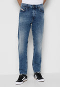 Blaue Jeans aus Denim mit geradem Bein, ausgestattet mit vorderen Taschen und Branding am Bund. Getragen mit schwarzen Sneakers.