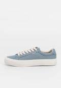 Blaue Leinenschuhe mit weißer Gummisohle, beigen Schnürsenkeln und einem Logolabel an der Seite. Abgerundete Spitze und strukturierte Stoffoberfläche.