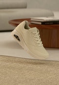 Beiger Sneaker mit Mesh-Obermaterial, Schnürverschluss und perforierten Details. Verfügt über eine sichtbare Air-Dämpfungseinheit in der Sohle.
