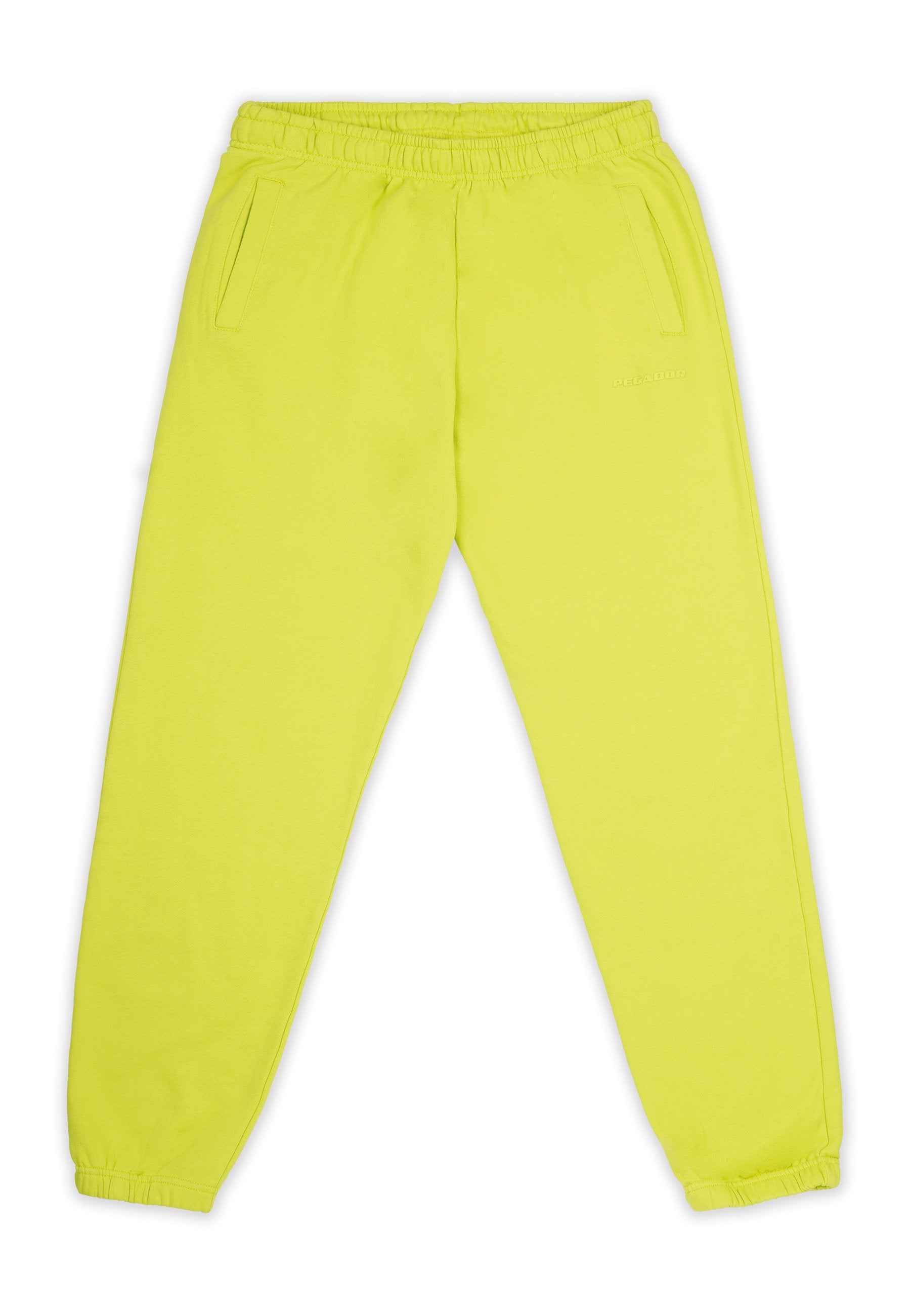 Neon-gelbe Jogginghose mit elastischem Bund, zwei Seitentaschen und schmal zulaufenden Bündchen. Glatte Textur, minimales Branding.