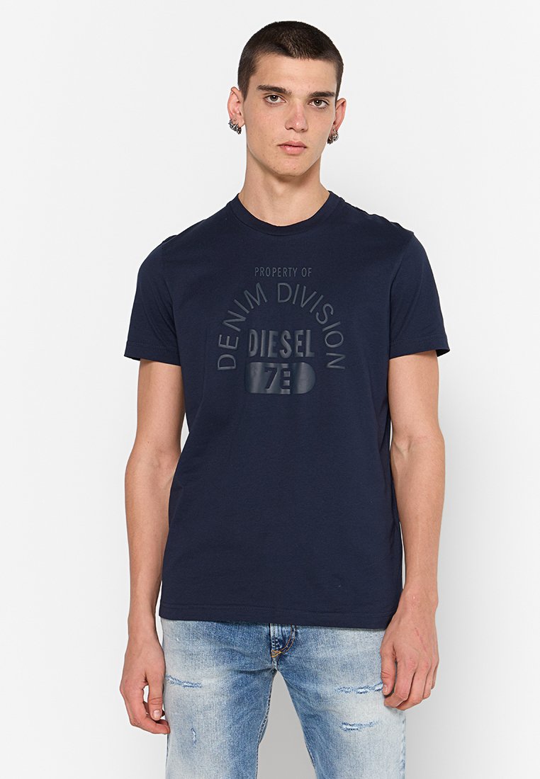 Navyblaue Baumwoll-T-Shirt mit rundem Halsausschnitt, kurzen Ärmeln und einem erhöhten Logo-Druck "Property of Denim Division Diesel" auf der Vorderseite.