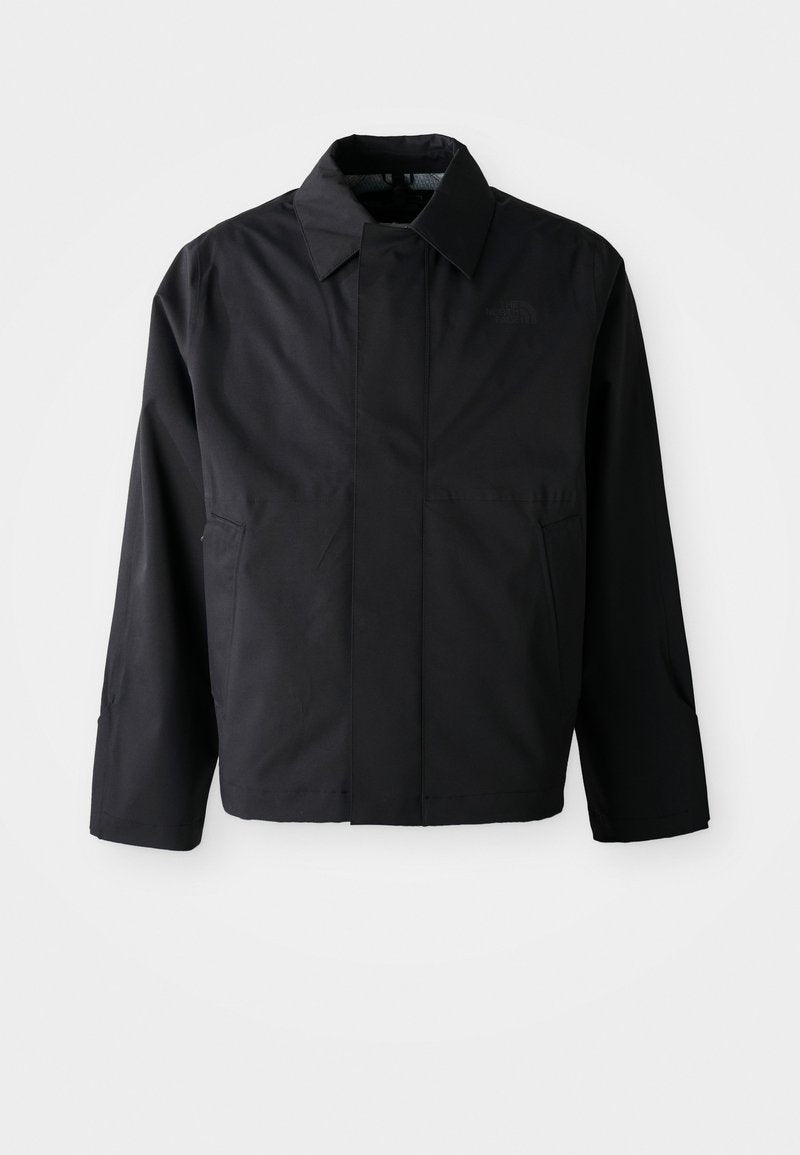Schwarze, kurze Jacke mit umgeschlagenem Kragen, zwei Fronttaschen und langen Ärmeln. Hergestellt aus glattem, leichtem Material mit dezentem Branding.