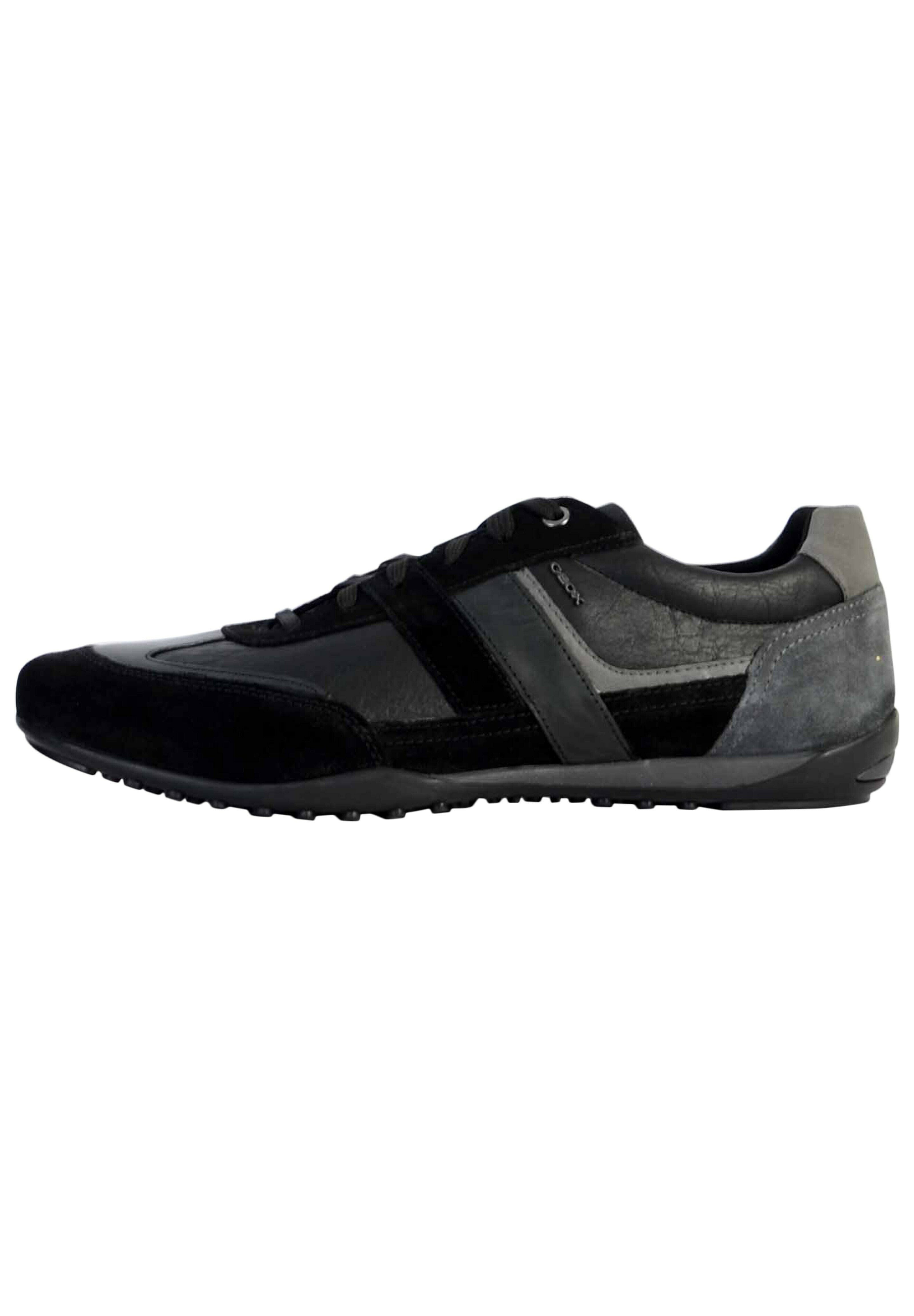Schwarze und graue Sportschuhe aus einer Mischung von Wildleder und Leder, mit einem schlanken Design, Schnürsenkeln und strukturierten Seitendetails.