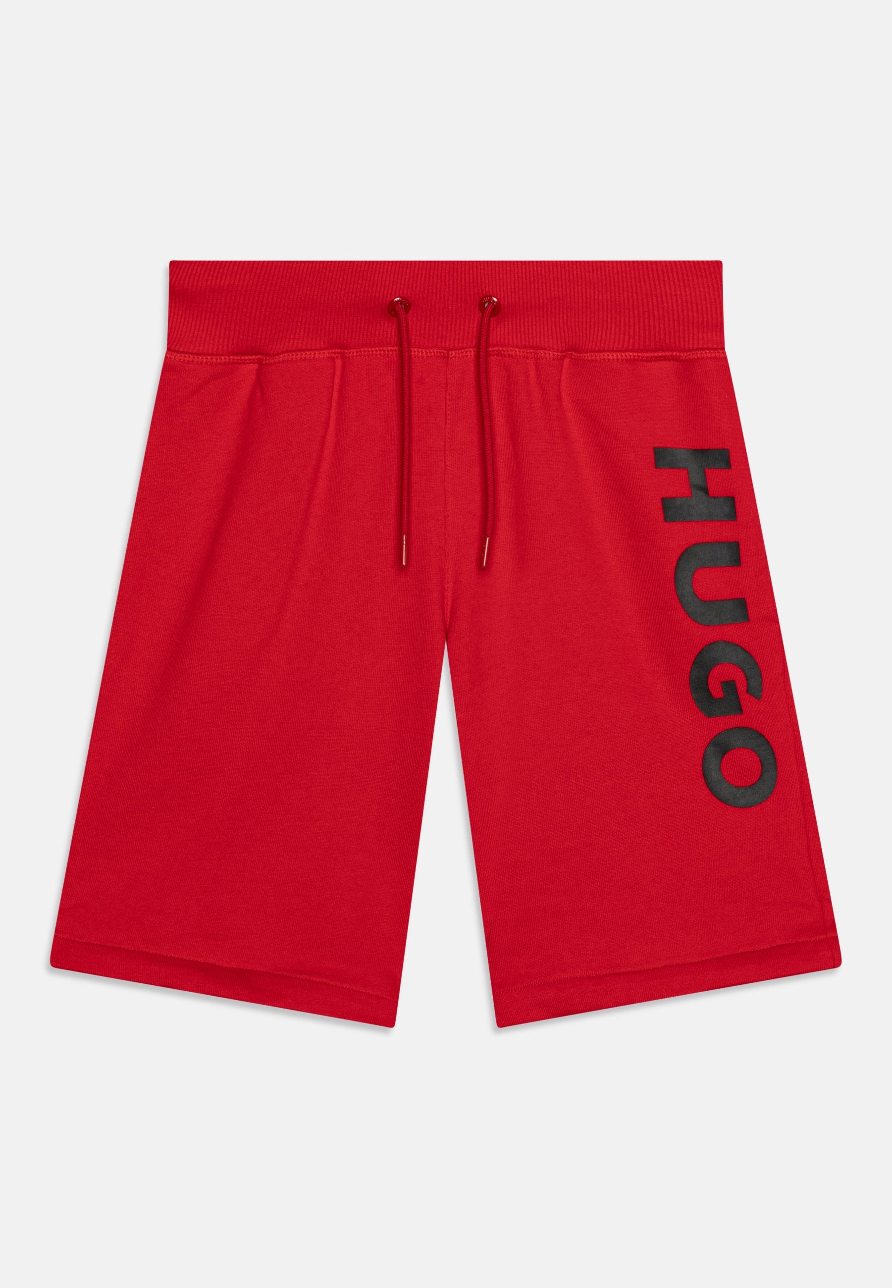Rote knielange Shorts mit elastischem Bund und Kordelzügen, mit großen schwarzen "HUGO"-Schriftzügen vertikal am rechten Bein.