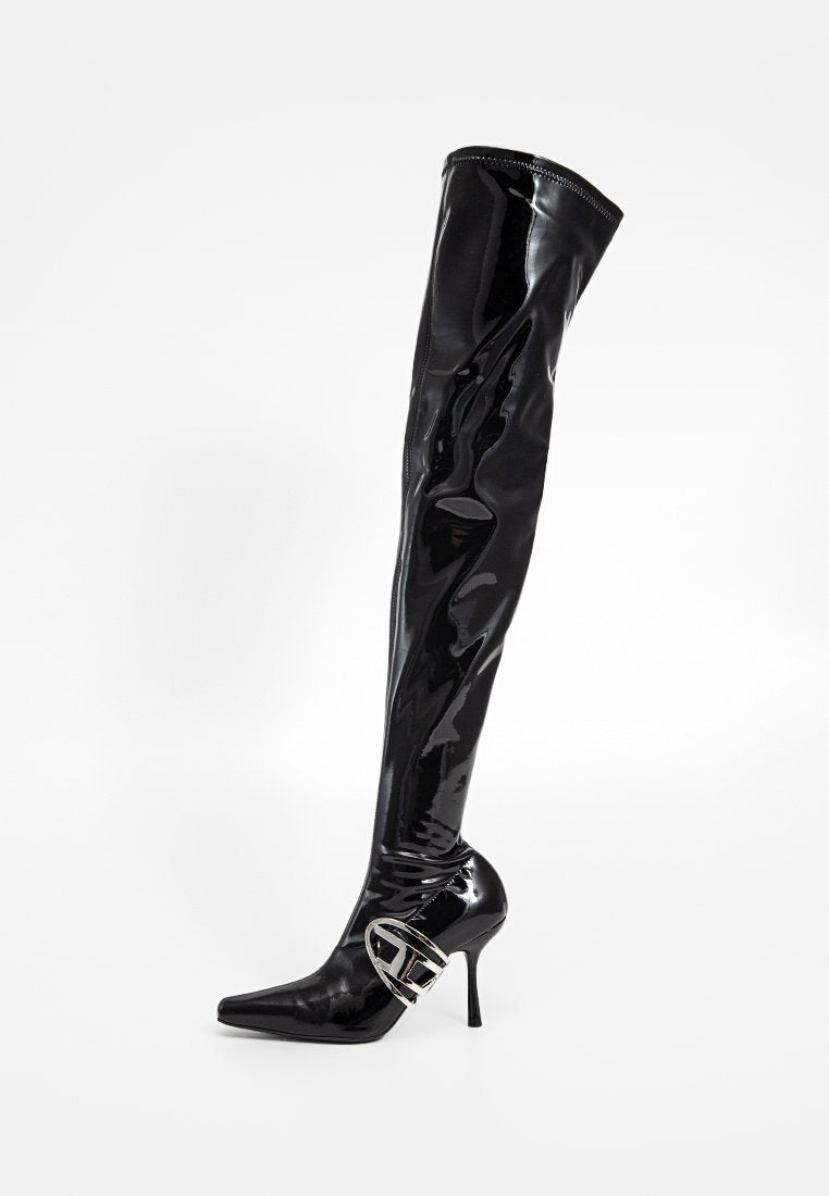 Schwarze Lackleder-Stiefel bis zum Oberschenkel mit spitzer Zehe und silbernem Schnallendetail oberhalb des Knöchels vor einem weißen Hintergrund.