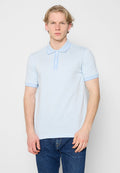 Hellblaues kurzärmeliges Poloshirt mit gemustertem Textureffekt, einer Knopfleiste mit drei Knöpfen und kontrastierendem Kragen sowie Ärmelabschlüssen. Kombiniert mit dunklen Jeans.