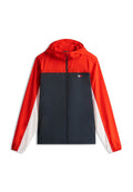 Kinder-Windjacke mit Kapuze in rotem Oberteil, navyblauem Mittelteil und weißen unteren Ärmeln, mit kleinem Logo auf der Brust.