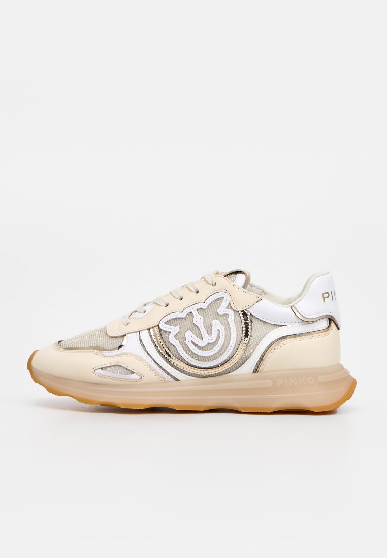 Beiger und weißer Sneaker mit Mesh- und Lederdetails, dicker beiger Sohle und einem lächelnden Gesichtslogo an der Seite.