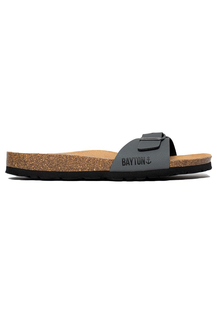 Graue Rutschsandalette mit Korkeinlage, verstellbarem Riemen und schwarzem Außensohle. Auf der Seite befindet sich der Schriftzug "BAYTON". Einfaches und flaches Design.
