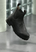 Schwarze Leder-Stiefeletten mit strukturierter Oberfläche, elastischen Seiteneinsätzen und einer robusten Gummisohle mit ausgeprägtem Profil.