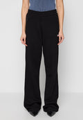 Schwarze, weit geschnittene Sweatpants mit einem elastischen Bund, zwei Reißverschlusstaschen und einem kleinen Logo-Detail an der linken Hüfte. Weicher, entspannter Schnitt.
