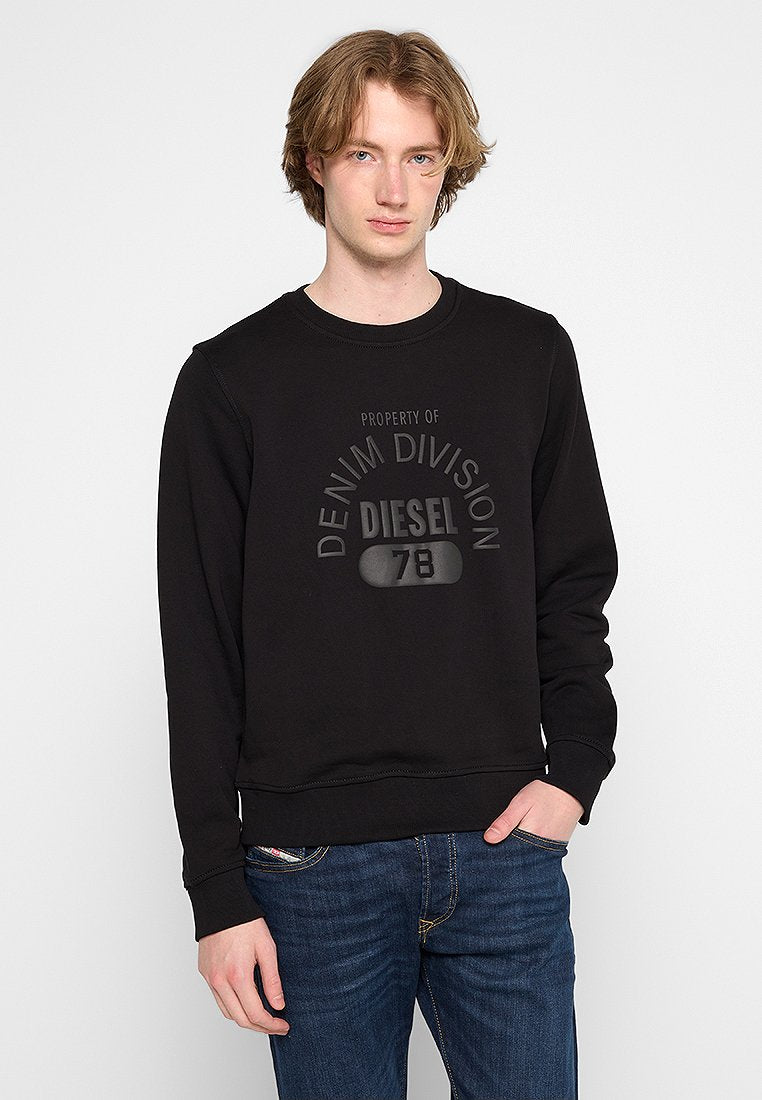 Schwarzer Hoodie aus weichem Material, mit Rundhalsausschnitt, gerippten Bündchen und geprägtem Textlogo, kombiniert mit dunkelblauen Jeans.