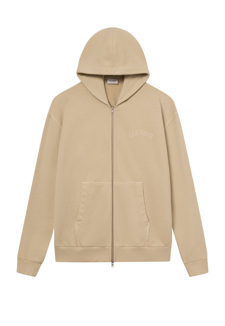 Beige Kapuzenpullover mit Reißverschluss, featuring einer Fronttasche und gerippten Bündchen. Minimalistisches Design mit gesticktem Text auf der Brust. Weiches Material.
