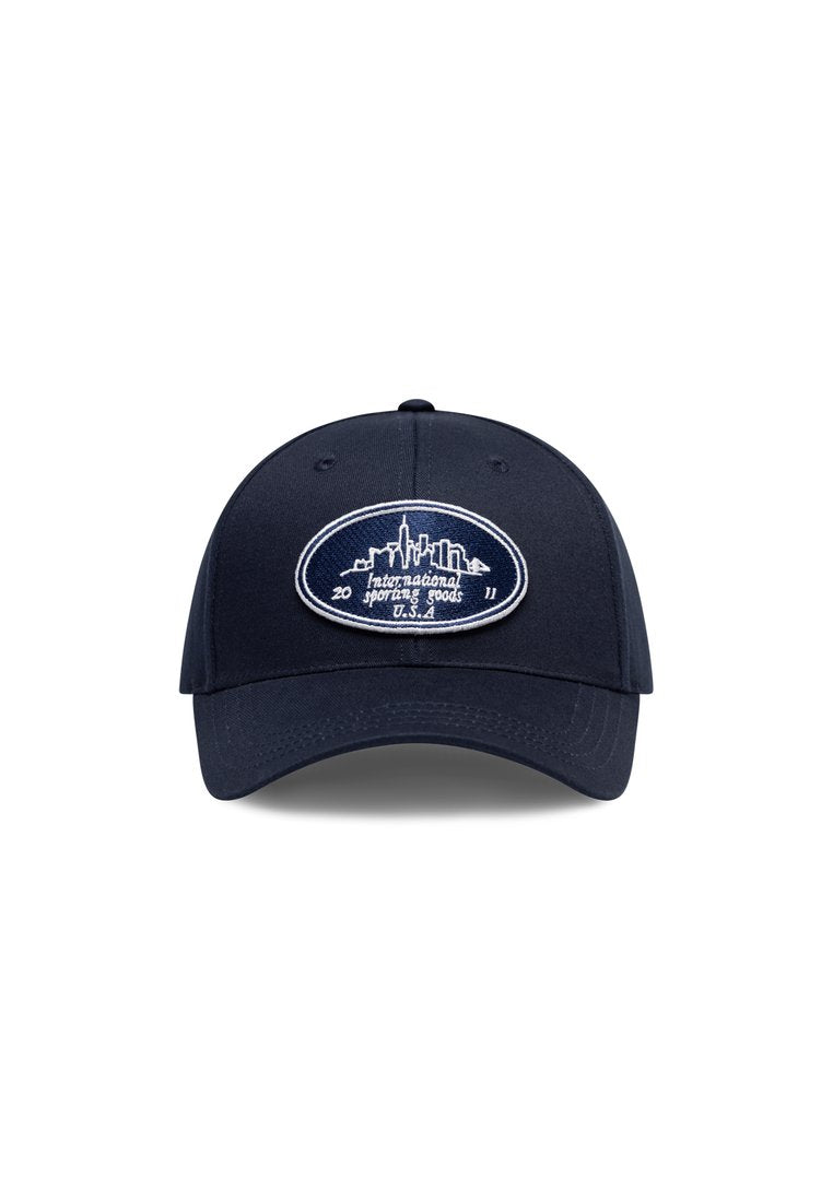 Marineblaue Baseballmütze mit einem gestickten weißen Logo, das eine Skyline zeigt, sowie dem Text "International Sporting Goods" und dem Jahr 2011.