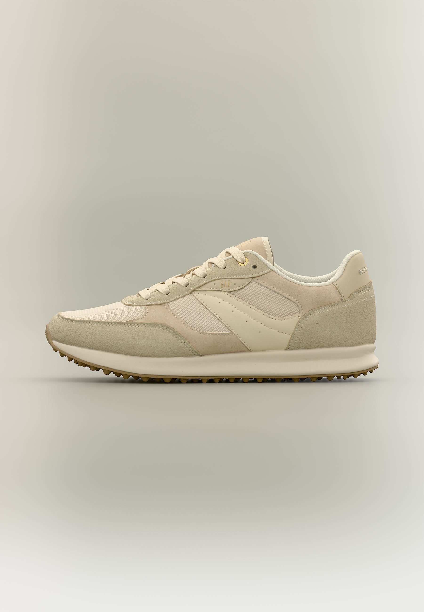 Beiger und cremefarbener Sneaker mit niedriger Schnittführung, Wildleder-Akzenten, Mesh-Einsätzen, Schnürverschluss und strukturierter Gummisohle.