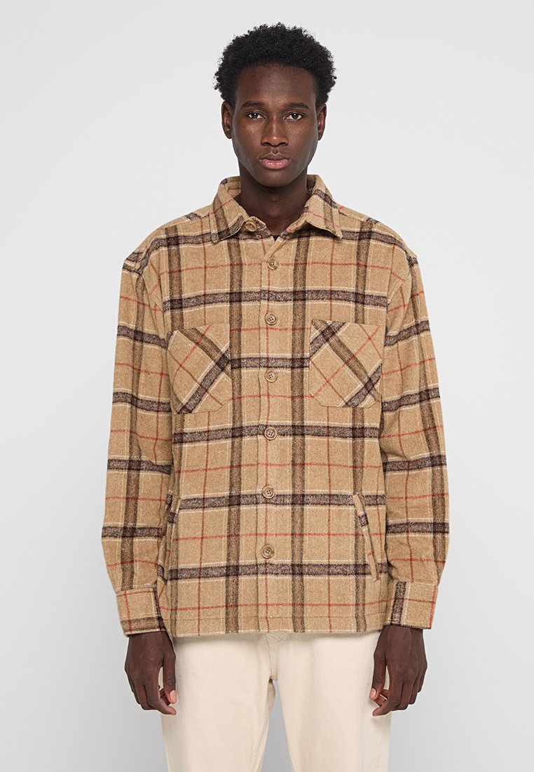 Braun kariertes Hemdjacke aus strukturiertem Stoff, mit großen Fronttaschen, Knöpfen und einem klassischen Kragendesign.