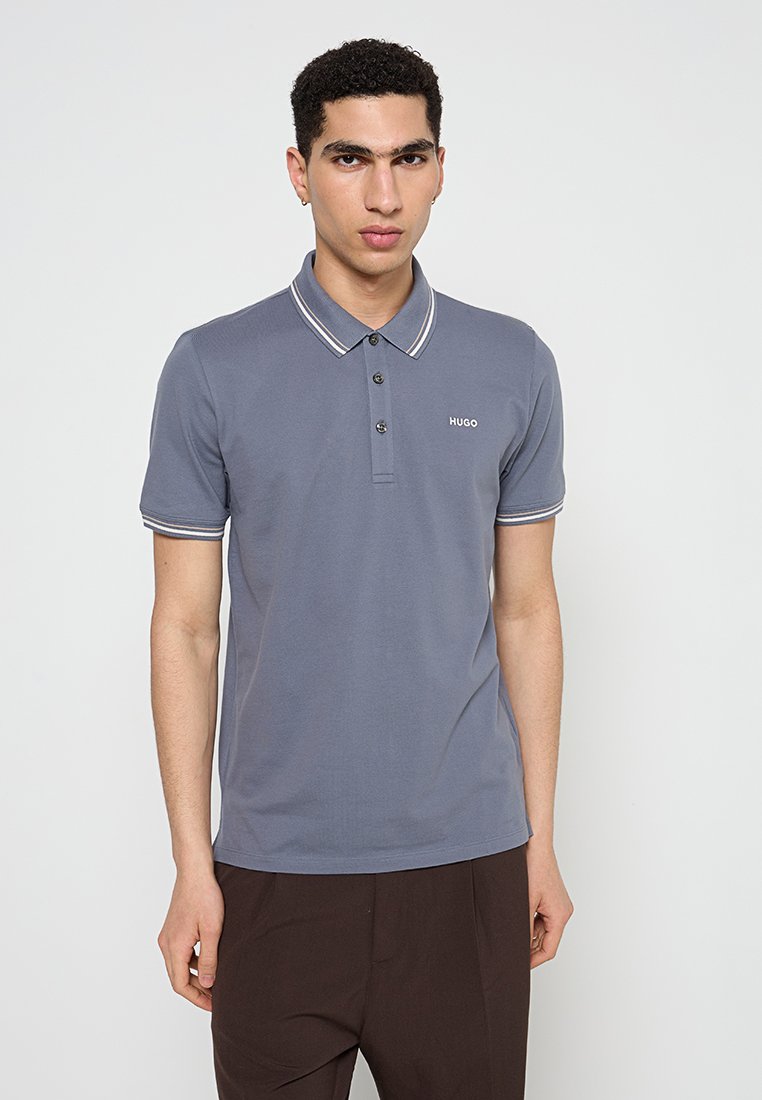 Graues Poloshirt mit Kragen, ausgestattet mit einer mit zwei Knöpfen versehenen Knopfleiste, kontrastierenden weißen Streifen am Kragen und an den Ärmeln sowie einem kleinen Logo auf der Brust.