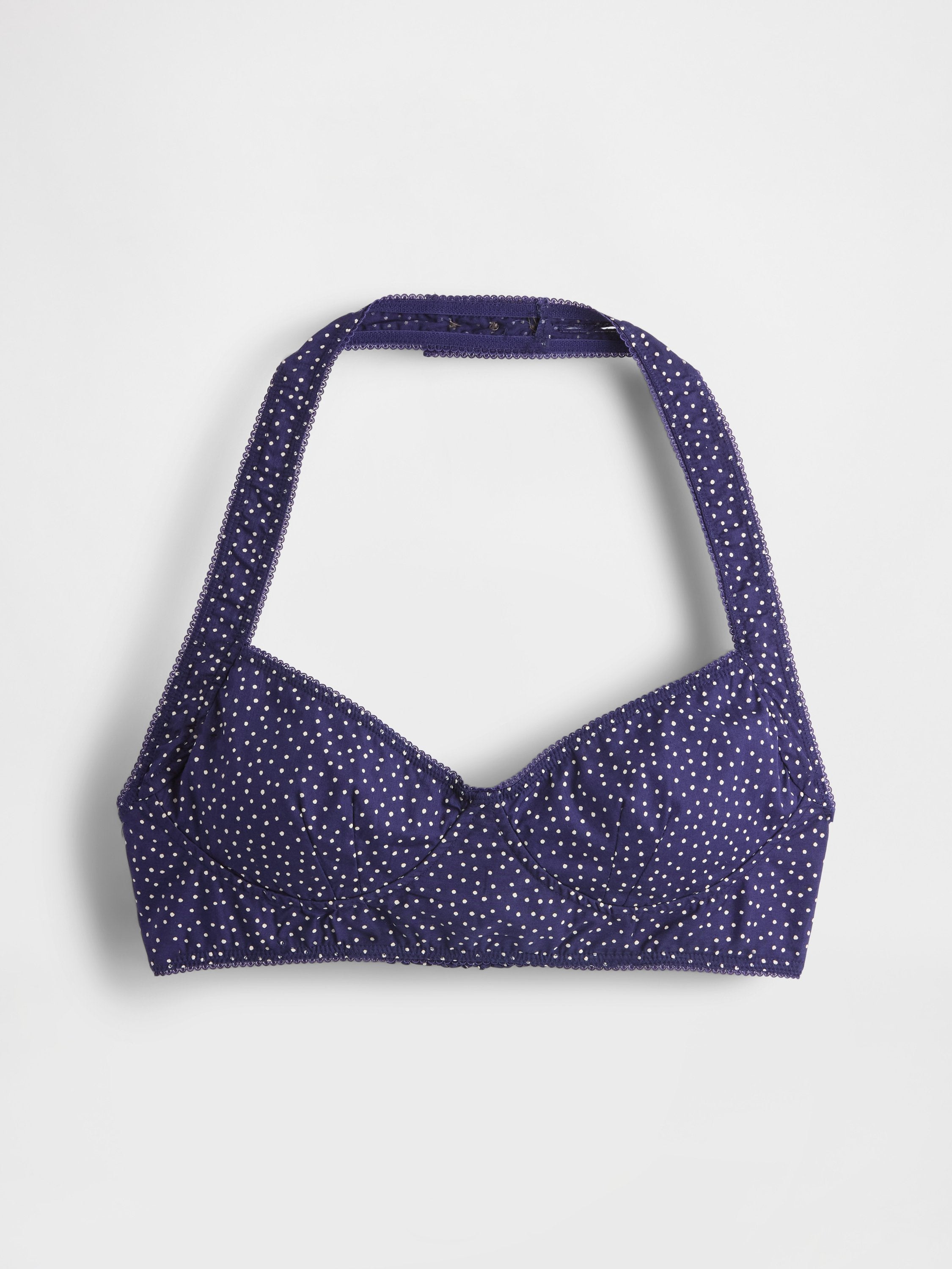 Lila Halter-Bikini-Oberteil mit weißen Polka-Dots, leicht gepolsterten Cups, gewelltem Saum und verstellbaren Trägern für eine anpassbare Passform.