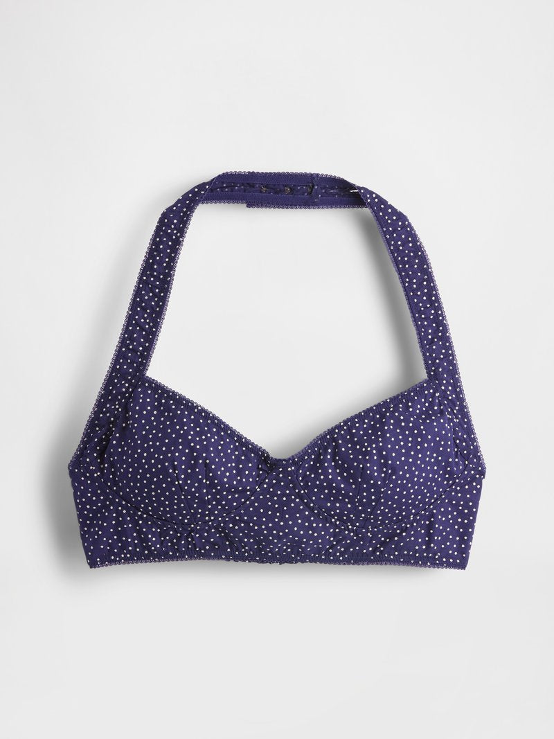 Lila Halter-Bikini-Oberteil mit weißen Polka-Dots, leicht gepolsterten Cups, gewelltem Saum und verstellbaren Trägern für eine anpassbare Passform.