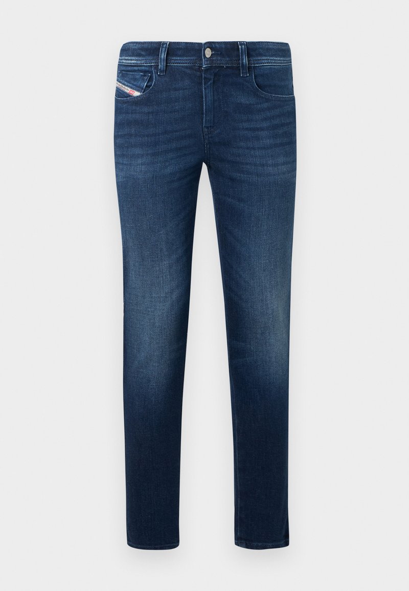 Dunkelblaue, schlanke Denim-Jeans mit verwaschenen Details und fünf Taschen, darunter eine kleine Münztasche mit sichtbarem Etikett.