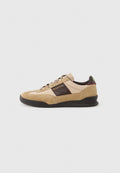 Beige Wildleder-Sneaker mit einer strukturierten braunen Partie, kontrastierendem braunem Fersenbereich und mehrfarbigen Schnürsenkeln. Verfügt über eine schwarze Gummisohle und goldene Markenkennzeichnung.