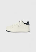 Weißer Sneaker mit einer leicht erhöhten Plattform, glatter Textur, schwarzen Akzenten an der Ferse und einem Logo an der Seite.