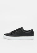 Schwarze Ledersneaker mit flacher, weißer Gummisohle, runder Spitze und sechs Ösen. Merkmale sind eine glatte Textur und minimale Markenkennzeichnung an der Ferse.