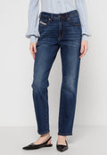 Dunkelblaue, gerade geschnittene Jeans mit einem Knopfverschluss, fünf Taschen, dezenten Ausbleichungen und kontrastierenden Nähten. Getragen mit einem hellen Pullover und schwarzen Ballerinas.