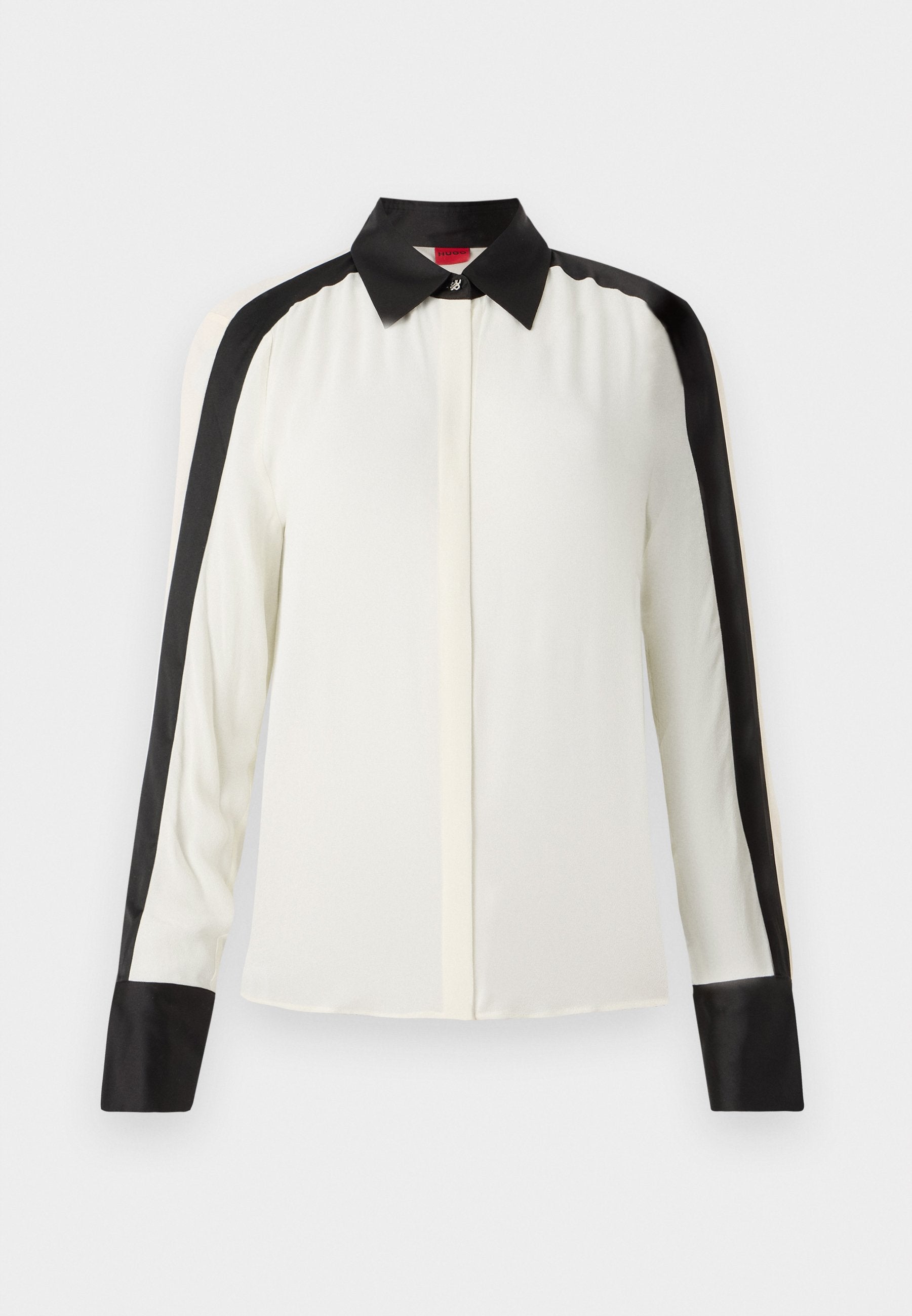 Weißes Blusenshirt mit schwarzen Satinakzenten entlang der Schultern und Manschetten, ausgestattet mit einem klassischen Kragen und langen Ärmeln aus einem glatten Stoff.