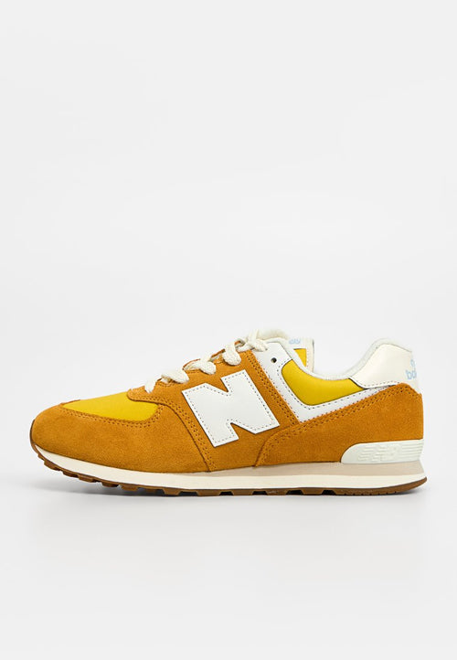 Gelber und brauner Wildleder-Laufschuh mit weißen Schnürsenkeln und einem weißen "N"-Logo an der Seite, dargestellt auf weißem Hintergrund.