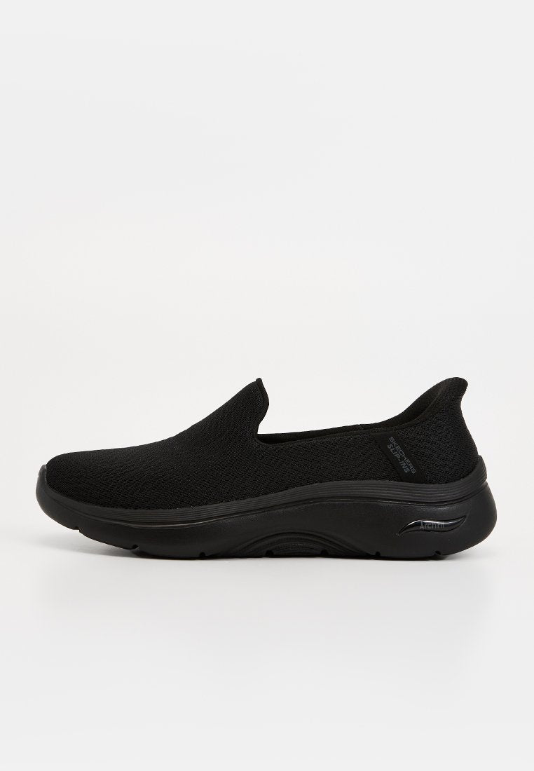 Schwarzer Slip-On-Sneaker mit gestricktem Obermaterial, gepolsterter Sohle und flachem Profil, entwickelt für Komfort und lässiges Tragen.