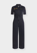 Dunkelblauer Marine-Kurzarm-Overall mit vorderem Reißverschluss, Brusttaschen, Bundschlaufen und gelben bestickten Aufnähern auf Brust und Ärmeln.